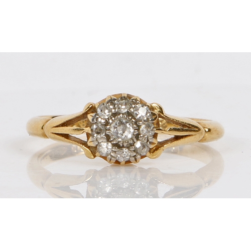 18 - An 18 carat gold ring set with a central diamond surrounded by a band of eight diamond chips, ring s... 