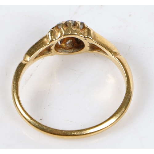 18 - An 18 carat gold ring set with a central diamond surrounded by a band of eight diamond chips, ring s... 