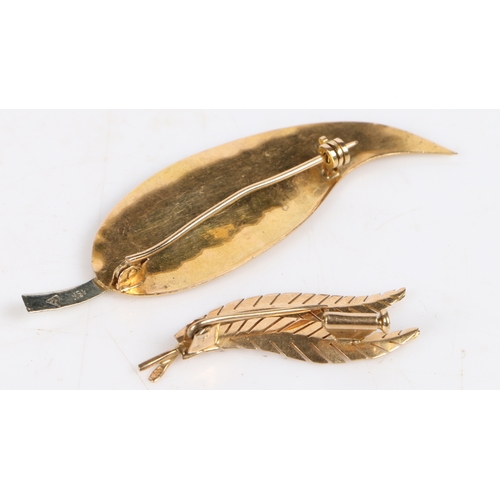 23 - An 18 carat white and yellow gold brooch modelled as a leaf, 63mm wide, 6.9g, an 18 carat gold brooc... 