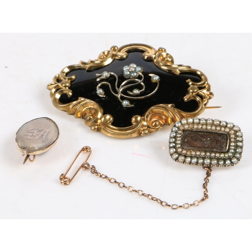 24 - A Victorian yellow metal, black enamel and pearl mourning brooch, the pearl set foliate centre on a ... 