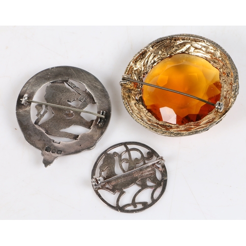 33 - A yellow metal and cairngorm set plaid brooch, the central prismatic cut stone surrounded by a wrapp... 