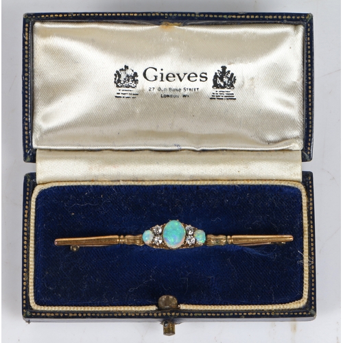 54 - An 18 carat gold bar brooch set with a central oval opal flanked by four diamonds and a further two ... 