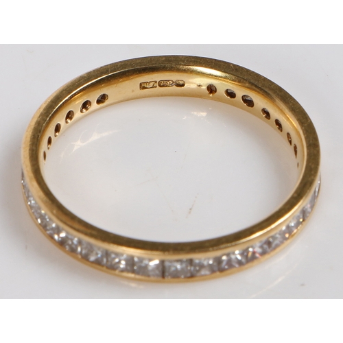 6 - An 18 carat gold and diamond eternity ring, channel set with 32 princess cut diamonds measuring appr... 