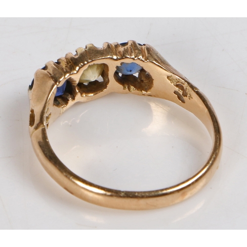 61 - A yellow metal, diamond and sapphire ring, the head set with a central round cut diamond flanked by ... 