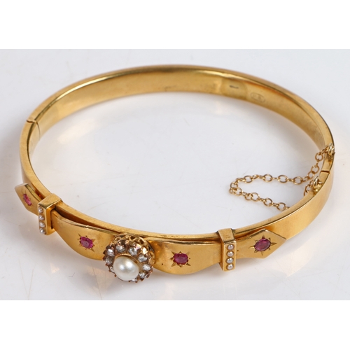 74 - A Victorian yellow metal, pearl, diamond and ruby bangle, with central pearl surrounded by a band of... 