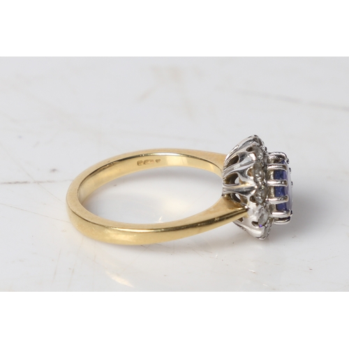 89 - An 18 carat gold, tanzanite and diamond ring, the central round facet cut tanzanite surrounded by a ... 