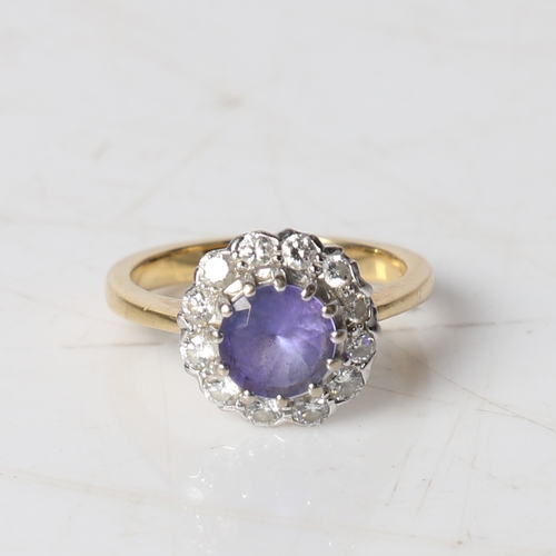 89 - An 18 carat gold, tanzanite and diamond ring, the central round facet cut tanzanite surrounded by a ... 