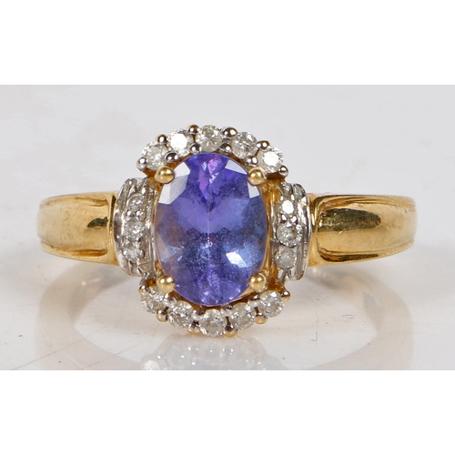 91 - An 18 carat gold tanzanite and diamond ring, the central oval facet cut tanzanite surrounded by a ba... 