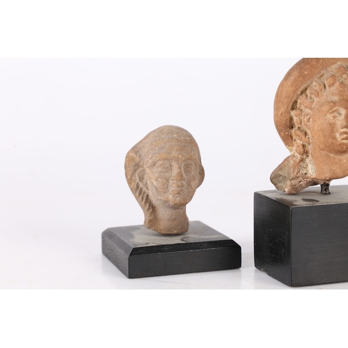 18 - TWO ANCIENT ETRUSCAN TERRACOTTA BUSTS, CIRCA 3RD-2ND CENTURY B.C (2). The first a female head raised... 