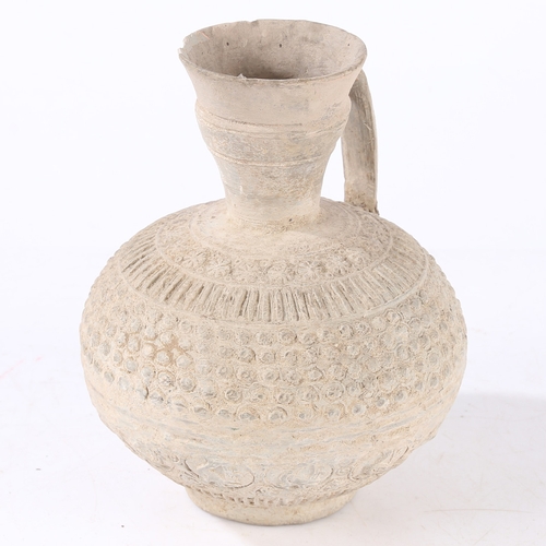 31 - AN EARLY ISLAMIC UNGLAZED POTTERY EWER, PERSIA OR SYRIA, 12TH/ 13TH CENTURY. Decorated with palmette... 