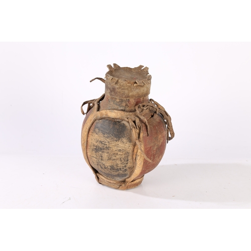 42 - AN AFRICAN WOODEN AND LEATHER WATER VESSEL. An African wooden and leather water vessel, early 20th c... 