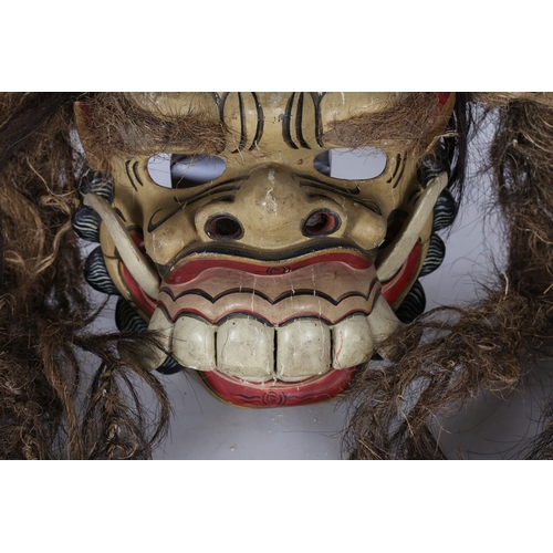 46 - A BALINESE CEREMONIAL GROTESQUE FACE MASK. A Balinese ceremonial grotesque face mask, having a paint... 