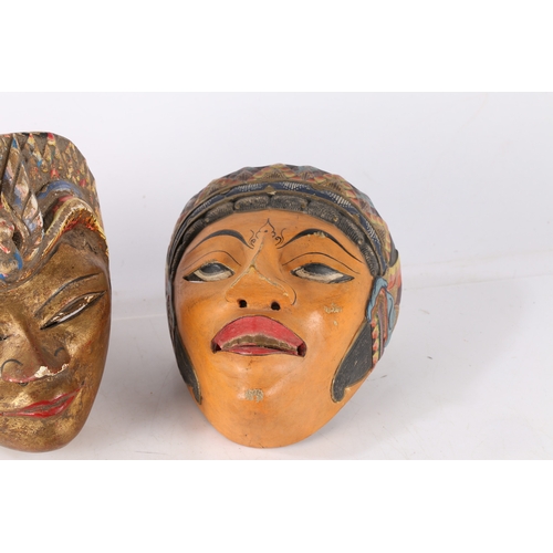 47 - THREE HAND PAINTED MASKS. Three hand painted masks, possibly Balinese, one having a gilt painted fac... 