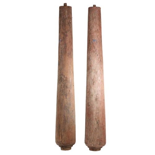 101 - A PAIR OF PINE COLUMNS. with faded red paint decoration, of tapering form with rounded bases, 174cm ... 