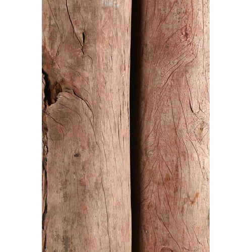 101 - A PAIR OF PINE COLUMNS. with faded red paint decoration, of tapering form with rounded bases, 174cm ... 