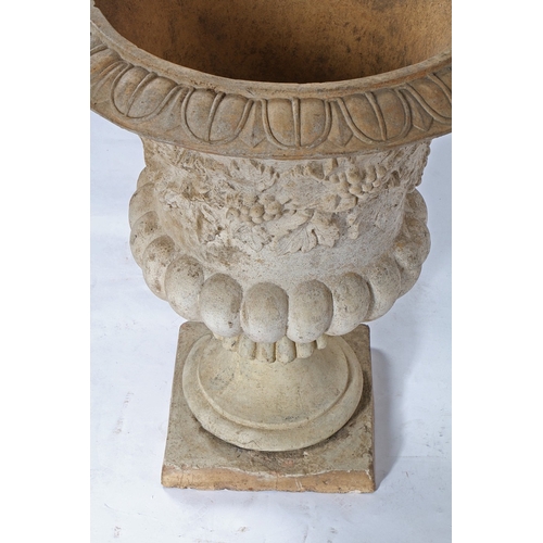 87 - A RECONSTITUTED STONE GARDEN URN. the fruiting vine decorated central band above a gadrooned lower s... 