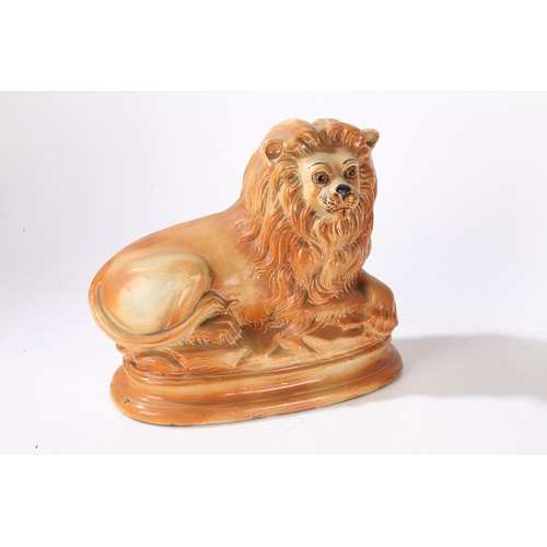 90 - A PAIR OF VICTORIAN STAFFORDSHIRE LIONS. modelled in recumbent positions with gilt highlighted manes... 