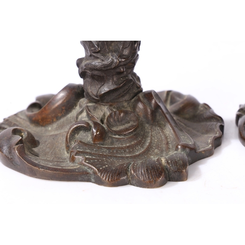 92 - A PAIR OF VICTORIAN BRONZE CANDLESTICKS. of foliate form with central entwined serpent, on a scroll ... 