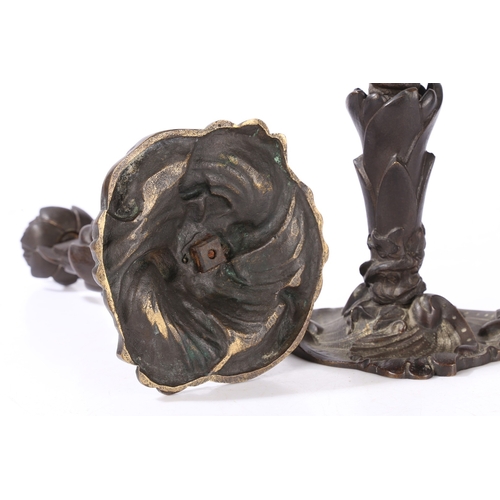 92 - A PAIR OF VICTORIAN BRONZE CANDLESTICKS. of foliate form with central entwined serpent, on a scroll ... 