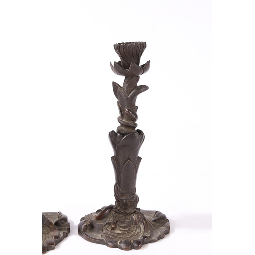 92 - A PAIR OF VICTORIAN BRONZE CANDLESTICKS. of foliate form with central entwined serpent, on a scroll ... 