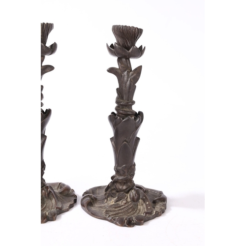 92 - A PAIR OF VICTORIAN BRONZE CANDLESTICKS. of foliate form with central entwined serpent, on a scroll ... 