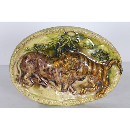 94 - A 19TH CENTURY STAFFORDSHIRE OVAL PLAQUE. depicting a tiger attacking an antelope, captioned 