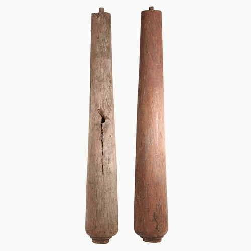 101 - A PAIR OF PINE COLUMNS. with faded red paint decoration, of tapering form with rounded bases, 174cm ... 