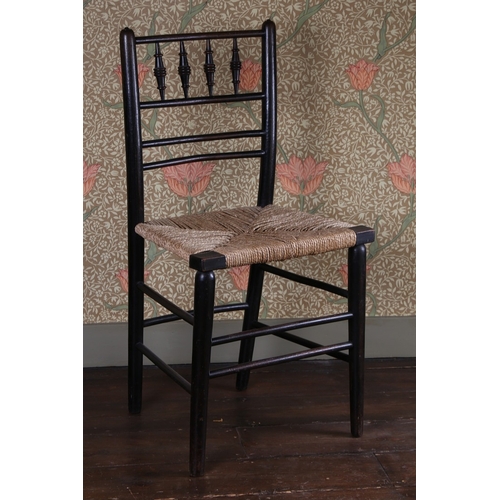 29 - A LATE 19TH CENTURY WILLIAM MORRIS EBONISED CHAIR. having a spindle back raised on a rush seat above... 