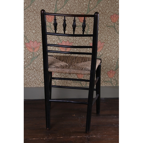 29 - A LATE 19TH CENTURY WILLIAM MORRIS EBONISED CHAIR. having a spindle back raised on a rush seat above... 