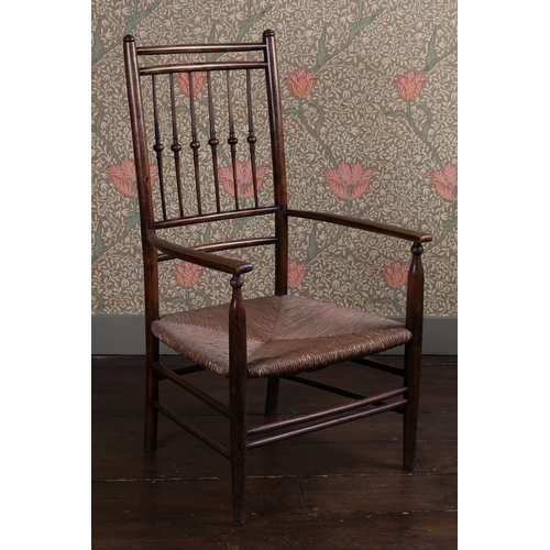 30 - A LATE 19TH CENTURY WILLIAM MORRIS ARMCHAIR. having a turned spindle back raised on rush seat having... 