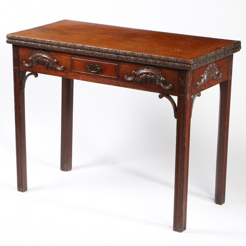 320 - AN EARLY GEORGE III CARVED MAHOGANY CARD TABLE. The hinged rectangular top opening to reveal a toole... 