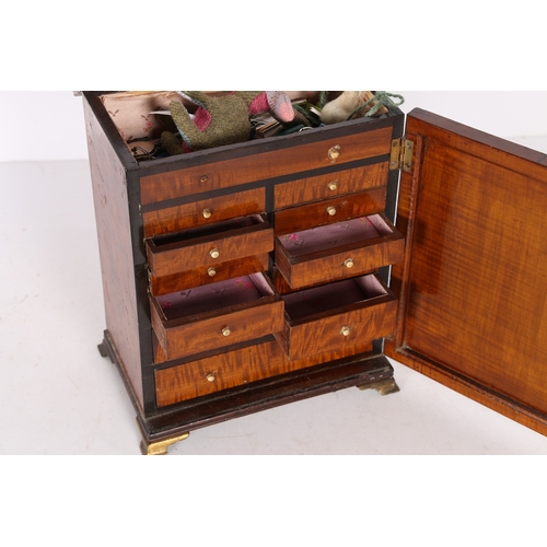 327 - A REGENCY SATINWOOD AND POLYCHROME PAINTED TABLE CABINET. modelled as a stylised wardrobe, the ebony... 