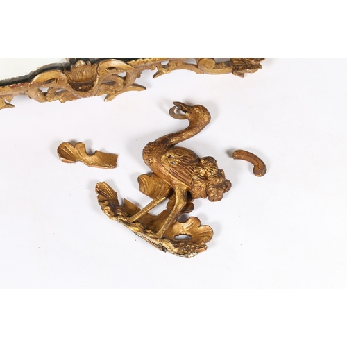 334 - A GEORGE III GILDED WALL MIRROR. the pediment depicting an ostrich type bird with snake in it's beak... 