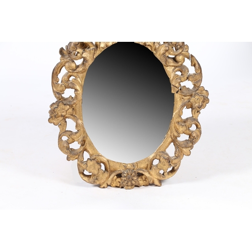 344 - A 19TH CENTURY FRENCH GILT WALL MIRROR. the oval mirror plate housed in a pierced foliate and scroll... 