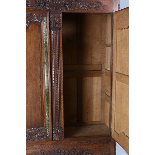 355 - A SUBSTANTIAL EARLY 20TH CENTURY FRENCH OAK ARMOIRE. the foliate and egg and dart pediment above a p... 