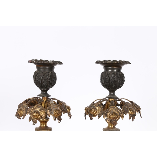 379 - A PAIR OF REGENCY STYLE STEEL AND GILT METAL CANDLESTICKS. the foliate cast sconces above pierced ha... 