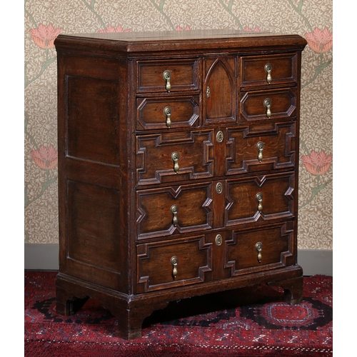 38 - A GEORGE III OAK EAST ANGLIAN GEOMETRIC CHEST OF DRAWERS. having a three plank top above four short ... 