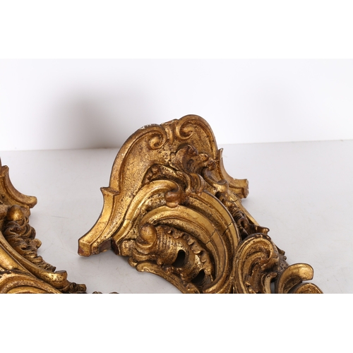 382 - A PAIR OF ROCOCO GILT WOOD BRACKETS. the scroll fronted shelved above pierced foliate and scroll dec... 