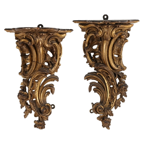 382 - A PAIR OF ROCOCO GILT WOOD BRACKETS. the scroll fronted shelved above pierced foliate and scroll dec... 