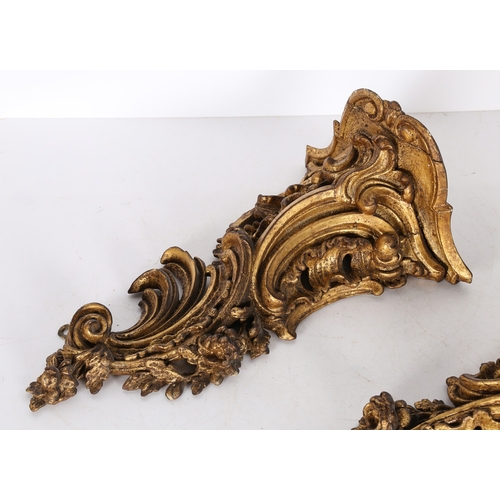 382 - A PAIR OF ROCOCO GILT WOOD BRACKETS. the scroll fronted shelved above pierced foliate and scroll dec... 