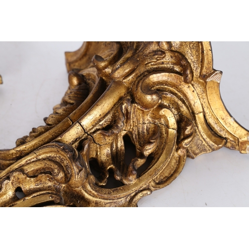 382 - A PAIR OF ROCOCO GILT WOOD BRACKETS. the scroll fronted shelved above pierced foliate and scroll dec... 