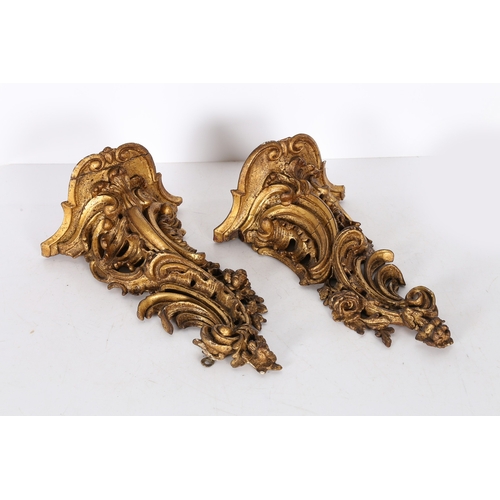 382 - A PAIR OF ROCOCO GILT WOOD BRACKETS. the scroll fronted shelved above pierced foliate and scroll dec... 