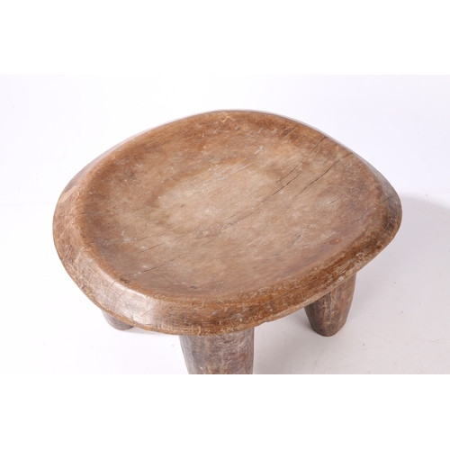 44 - A SENUFO STOOL, WEST AFRICA. the dished seat raised on four tapering legs, 36cm wide, 32.5cm deep, 2... 