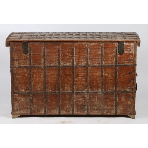 45 - AN INDIAN TEAK AND IRON BOUND CHEST. the iron banded hinged lid with two locks, the banded front wit... 