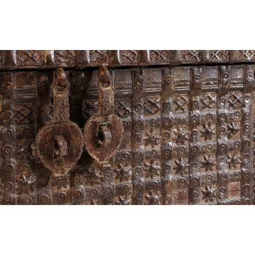 45 - AN INDIAN TEAK AND IRON BOUND CHEST. the iron banded hinged lid with two locks, the banded front wit... 