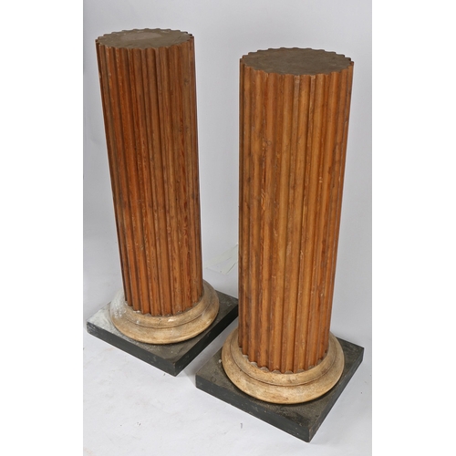 48 - A PAIR OF PINE PEDESTALS. the fluted columns above a spreading foot and square plinth base, 112cm hi... 