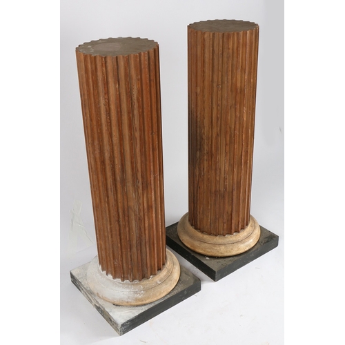 48 - A PAIR OF PINE PEDESTALS. the fluted columns above a spreading foot and square plinth base, 112cm hi... 