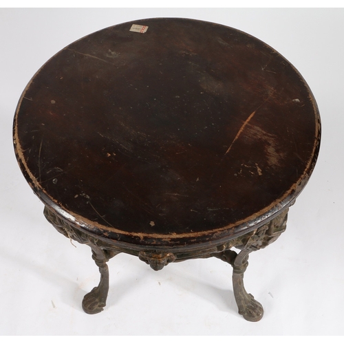 51 - A CAST IRON PUB TABLE. the later dark stained circular top above the cast iron base, the three legs ... 