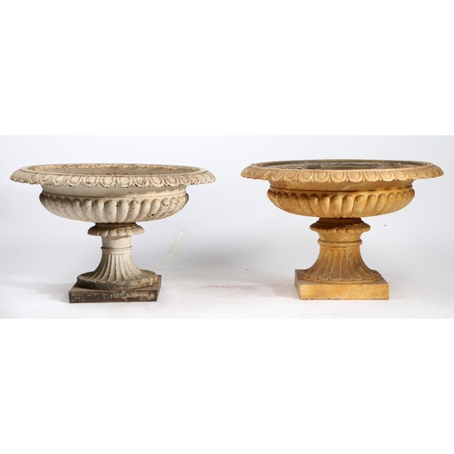 52 - A NEAR PAIR OF CAST IRON GARDEN URNS. of classical form with egg and dart rims, reeded bodies and st... 