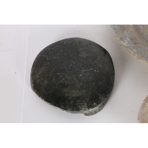 57 - AN INDIAN CHAPATI STONE, A LARGE AND TWO SMALL CARVED STONE DISHES (4). The chapati stone raised on ... 